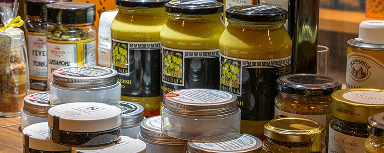 輸入食材の瓶詰めやトリュフ塩などの商品が並ぶ写真