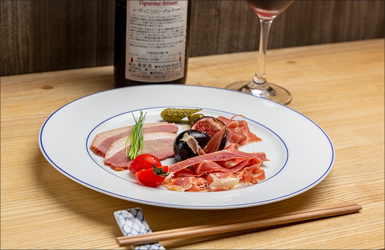 生ハムと鴨肉の盛り合わせと赤ワインの写真