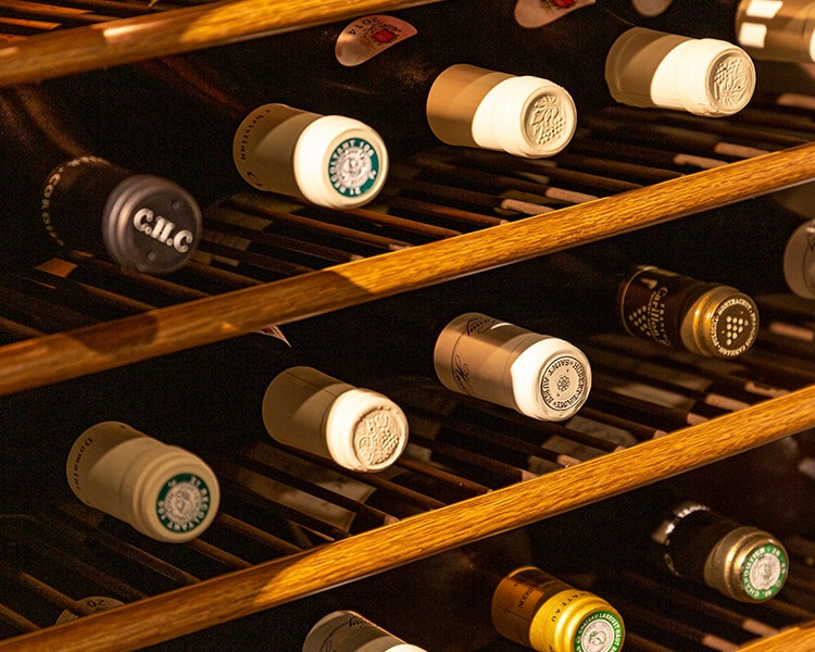 ワインボトルの首がセラーから覗く写真