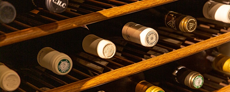 ワインセラーからボトルの首がいくつものぞく画像